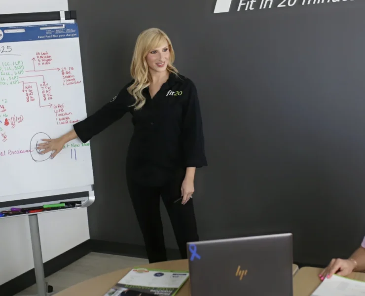 Two women at Fit20 reviewing a chart.